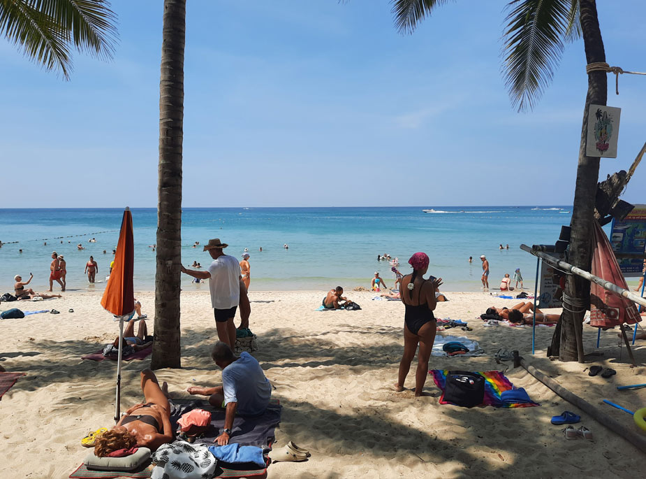 туристы в тени на пляже kamala beach